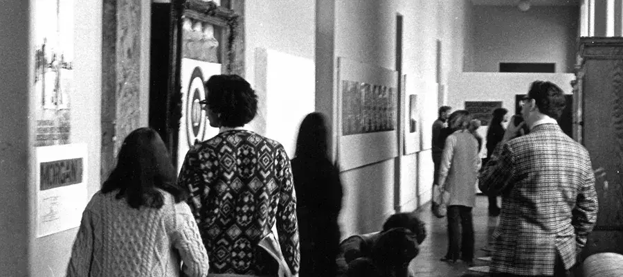 Visitors to Strategy: Get Arts (1970) inspecting work along the first-floor south corridor (from E.22 to E.25). Photo