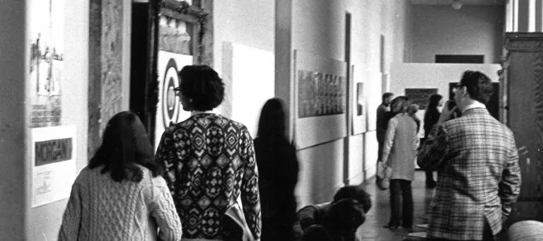 Visitors to Strategy: Get Arts (1970) inspecting work along the first-floor south corridor (from E.22 to E.25). Photo